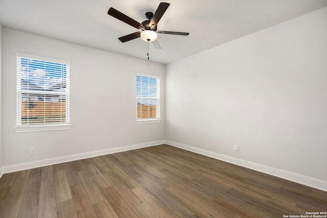 empty room with dark wood-style floors, ceiling fan, and baseboards