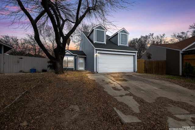 view of front of property featuring concrete driveway and fence