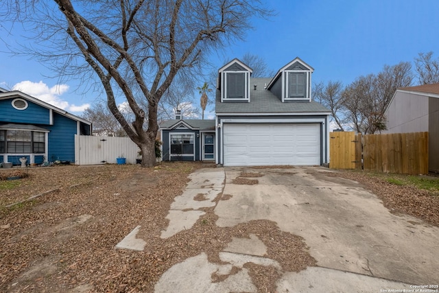 view of front of home featuring a garage, driveway, fence, and a gate