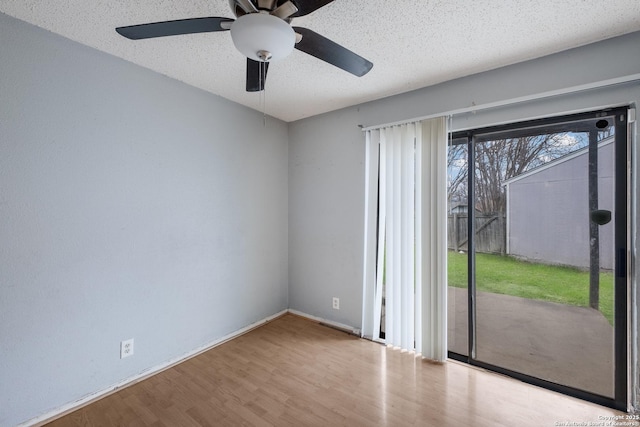 unfurnished room featuring light wood-type flooring, baseboards, and a textured ceiling