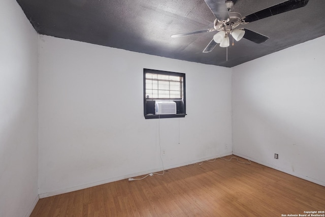 unfurnished room with a ceiling fan, cooling unit, a textured ceiling, and wood finished floors