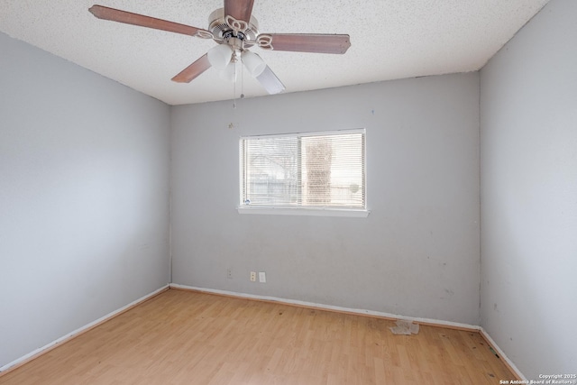 unfurnished room with a textured ceiling, ceiling fan, baseboards, and light wood-style floors