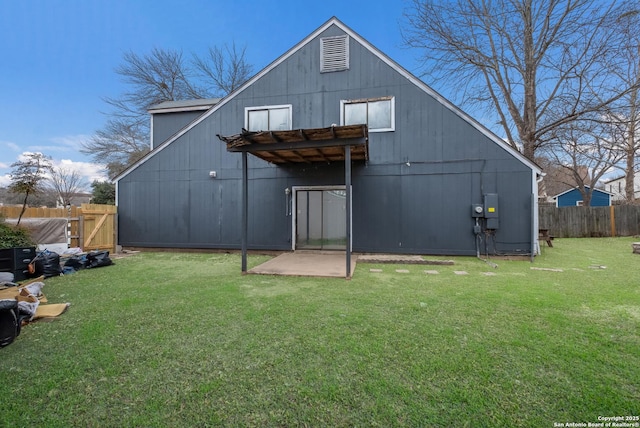 rear view of house with a lawn and fence