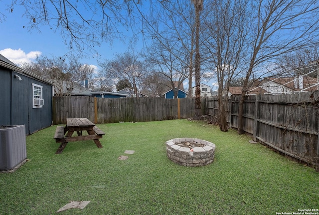 view of yard with a fire pit, a fenced backyard, and central air condition unit