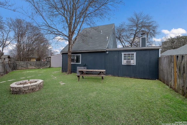 view of yard featuring a fenced backyard, a fire pit, and cooling unit