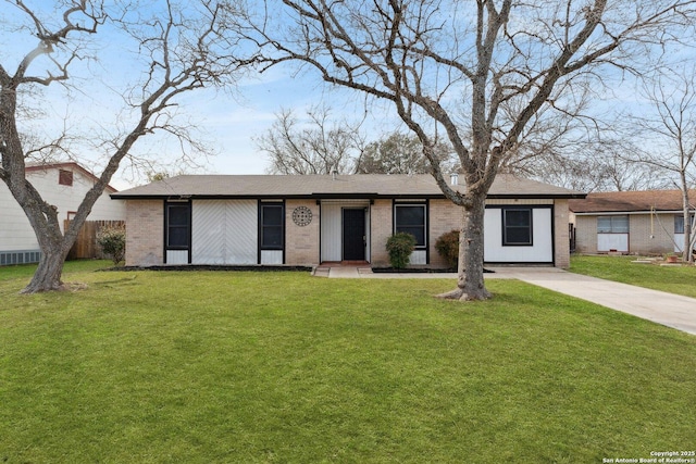 view of front facade featuring a front yard, brick siding, and driveway