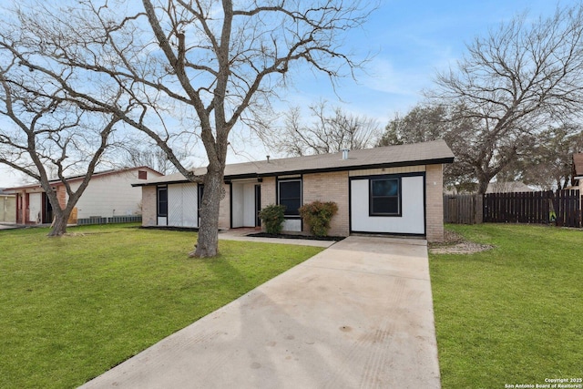 view of front of home featuring a front yard, fence, and brick siding