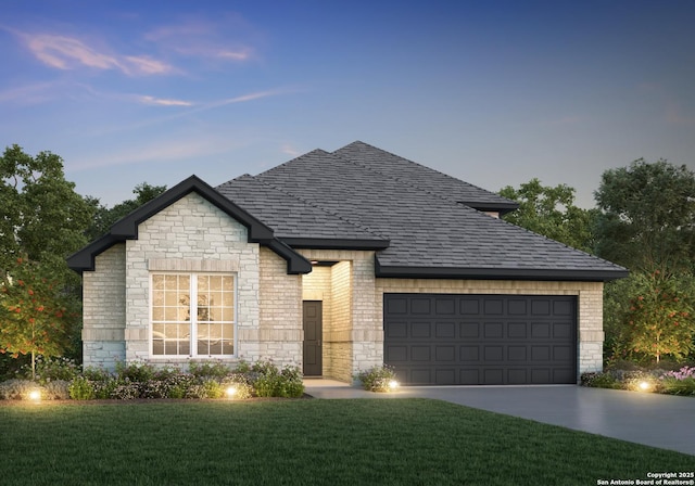 view of front of house with an attached garage, driveway, a shingled roof, and a yard