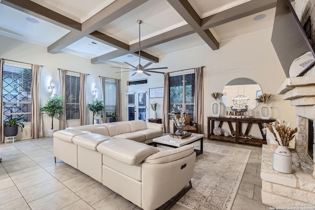 living room with a ceiling fan, coffered ceiling, beamed ceiling, and a fireplace with raised hearth