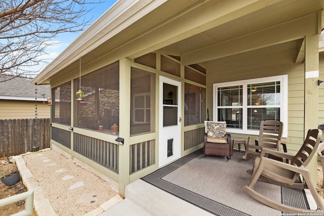 view of patio / terrace featuring a sunroom and fence