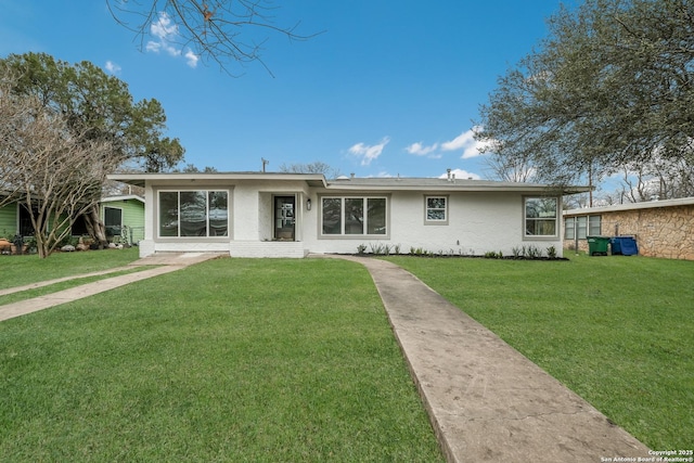 back of property with a lawn and stucco siding