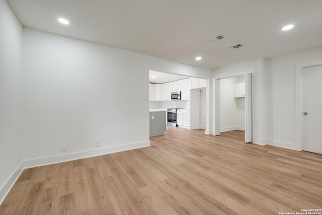 unfurnished living room with light wood finished floors, visible vents, and recessed lighting