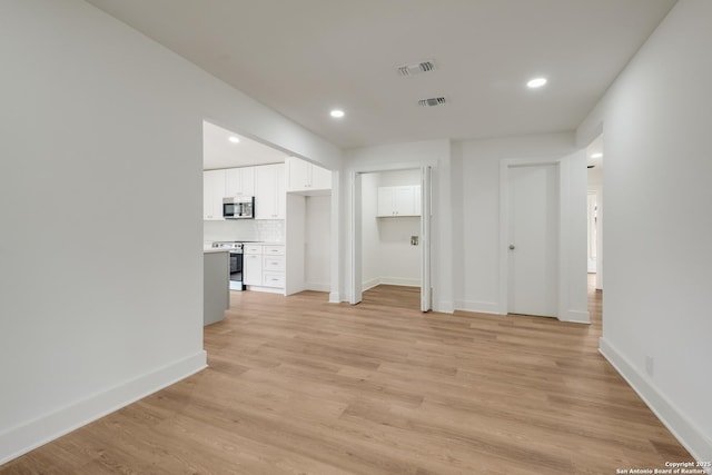 unfurnished room with light wood-type flooring, visible vents, baseboards, and recessed lighting