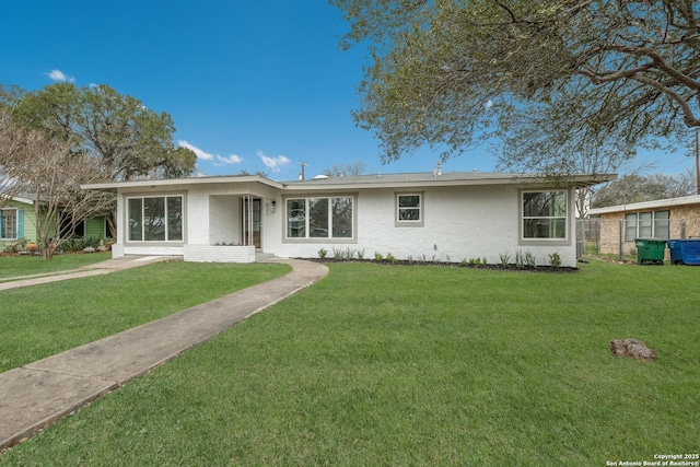 view of front of house with fence, a front lawn, and stucco siding