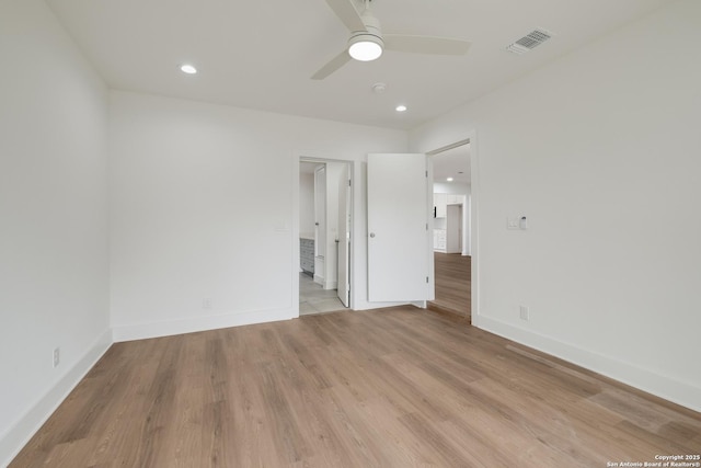 unfurnished room featuring a ceiling fan, baseboards, visible vents, and light wood finished floors