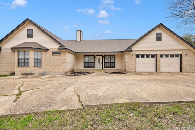 view of front facade featuring a chimney, concrete driveway, and brick siding