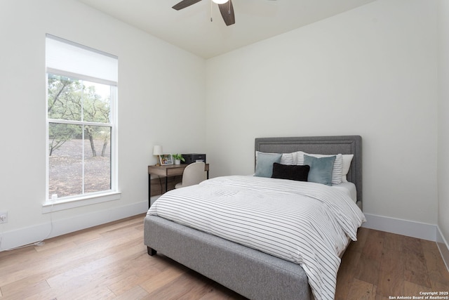 bedroom featuring light wood-style flooring, baseboards, and ceiling fan