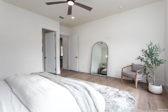 bedroom featuring a ceiling fan, light wood-type flooring, visible vents, and baseboards