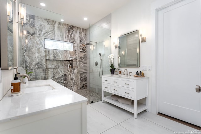 bathroom featuring recessed lighting, two vanities, a sink, and a walk in shower