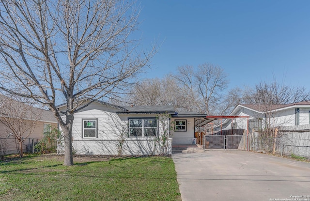 view of front of house featuring fence, a front lawn, a carport, and concrete driveway