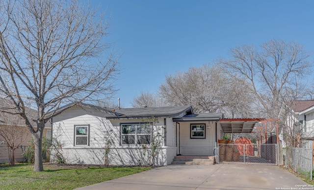 single story home with concrete driveway, a carport, and fence