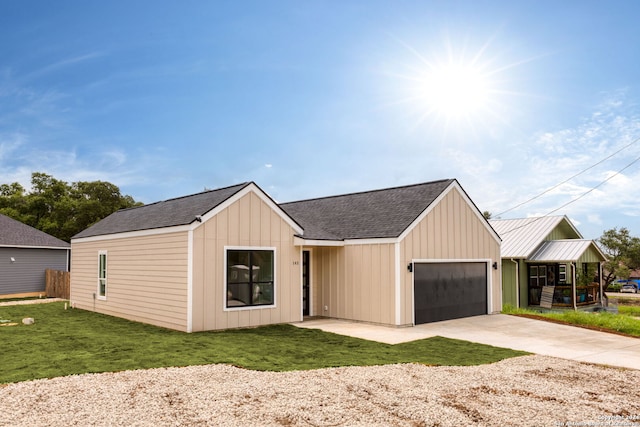 modern inspired farmhouse featuring driveway, a shingled roof, an attached garage, board and batten siding, and a front yard