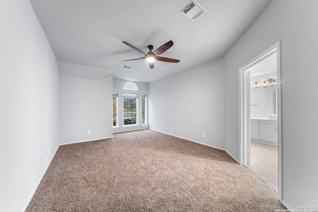 carpeted empty room with a ceiling fan, visible vents, and baseboards