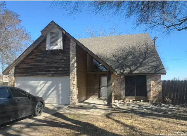 view of front of home featuring driveway, stone siding, and a shingled roof