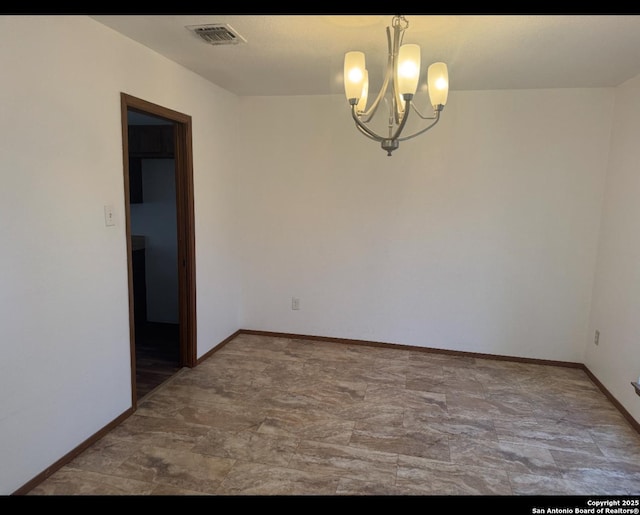 unfurnished room featuring baseboards, visible vents, and a notable chandelier