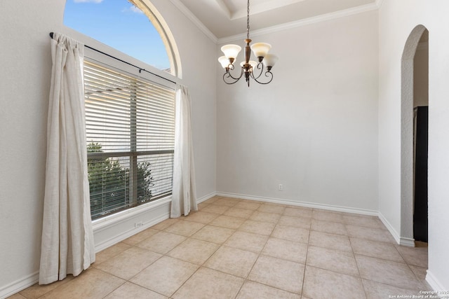 unfurnished room with ornamental molding, arched walkways, a notable chandelier, and baseboards