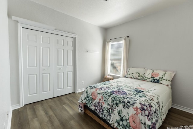 bedroom with a closet, baseboards, and wood finished floors