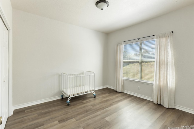 bedroom with baseboards and wood finished floors