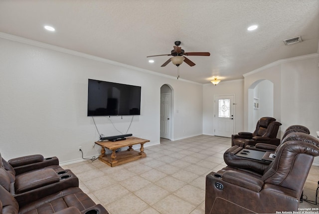 living area featuring baseboards, visible vents, arched walkways, and crown molding