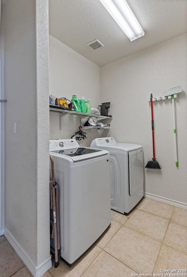 laundry area with light tile patterned floors, laundry area, visible vents, and washer and dryer