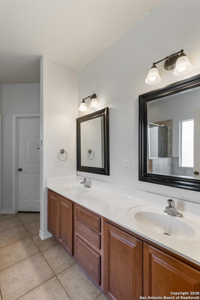 bathroom featuring double vanity, an enclosed shower, a sink, and tile patterned floors