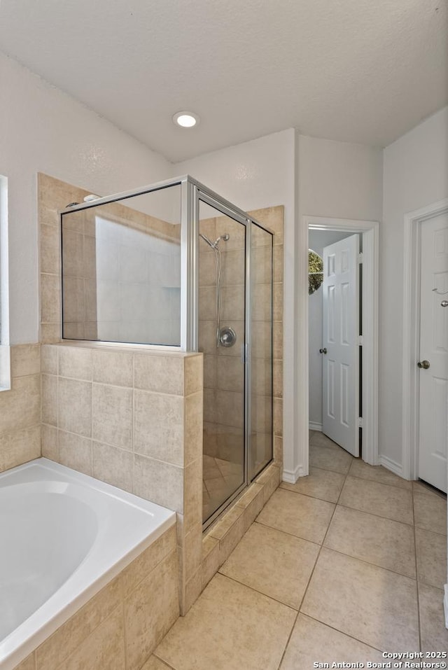 full bathroom featuring a stall shower, a garden tub, and tile patterned floors