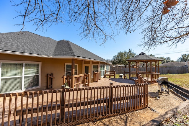 wooden deck featuring a gazebo, grilling area, and fence