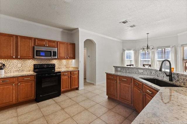 kitchen with a sink, visible vents, hanging light fixtures, black electric range oven, and stainless steel microwave