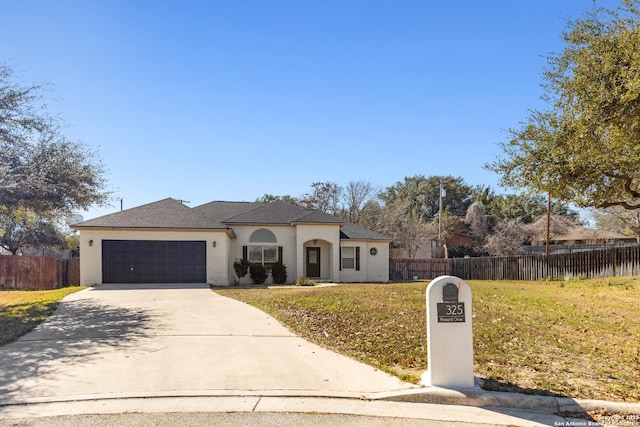 view of front of property featuring stucco siding, concrete driveway, an attached garage, a front yard, and fence