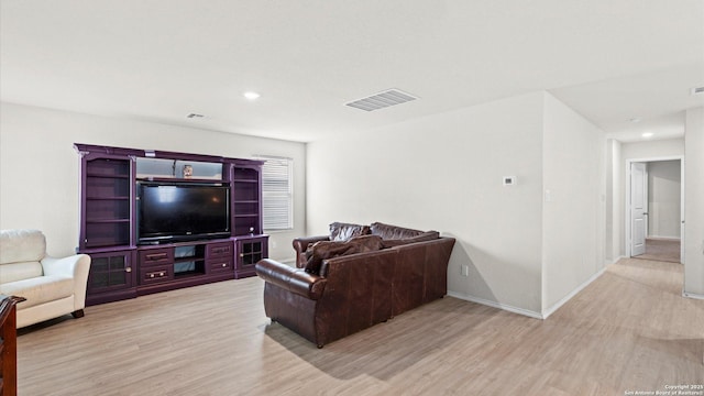 living room featuring light wood-style flooring, visible vents, baseboards, and recessed lighting