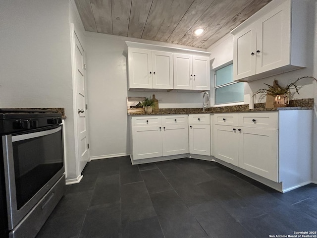 kitchen featuring stainless steel range with gas stovetop, dark stone countertops, and white cabinetry