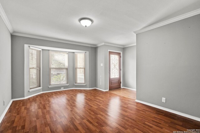 entryway featuring baseboards, wood finished floors, and ornamental molding