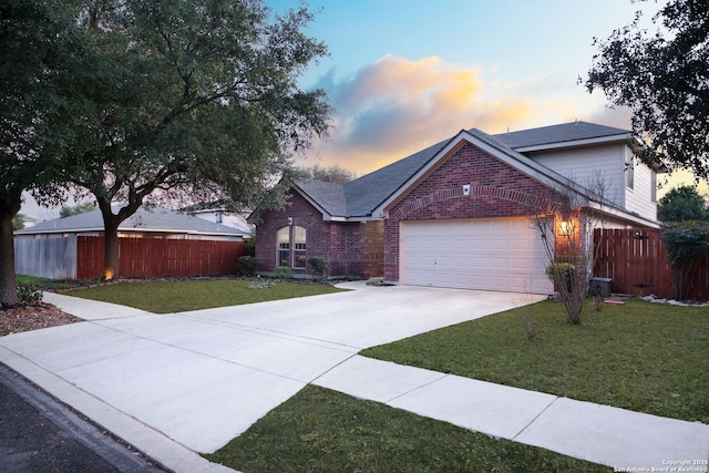 ranch-style house featuring driveway, an attached garage, fence, a yard, and brick siding