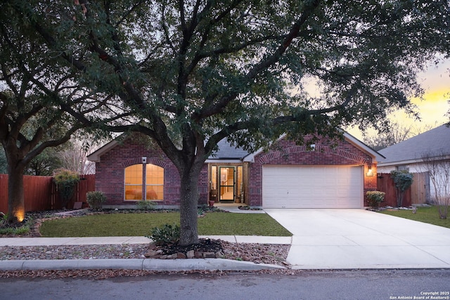 single story home featuring brick siding, concrete driveway, a front yard, fence, and a garage