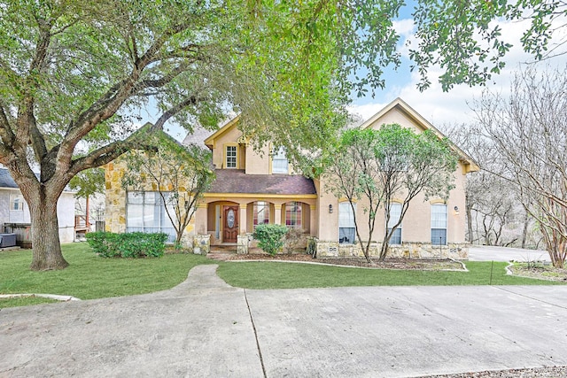 traditional-style house with a porch, a front lawn, concrete driveway, and stucco siding