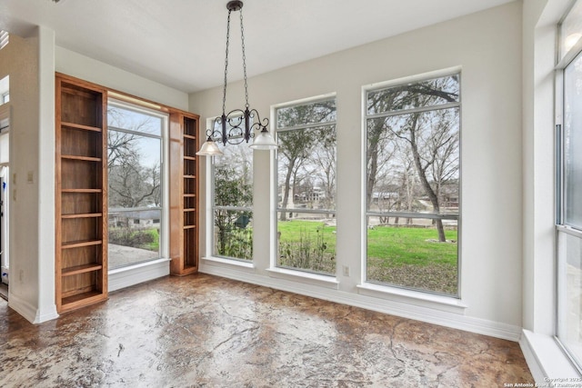 unfurnished dining area with a chandelier and plenty of natural light