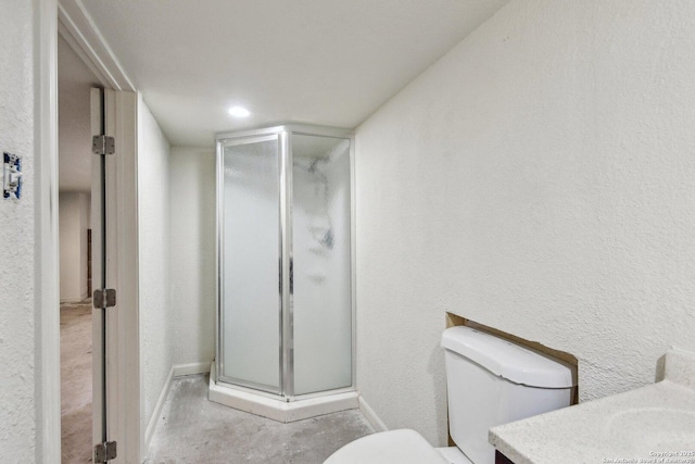 full bathroom with a shower stall, a textured wall, vanity, and toilet