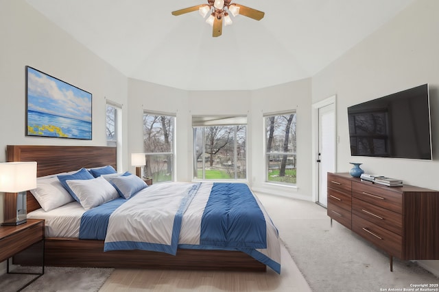 bedroom with light carpet, vaulted ceiling, and ceiling fan