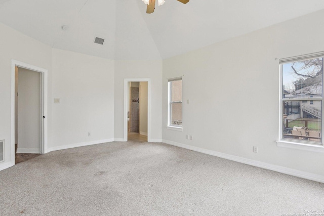 empty room with carpet, visible vents, high vaulted ceiling, and baseboards