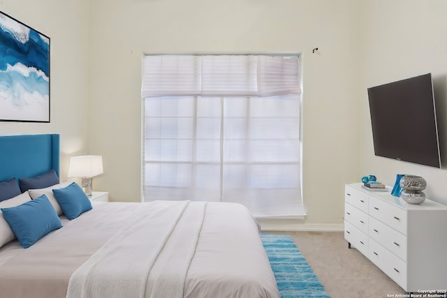 bedroom with light carpet and baseboards